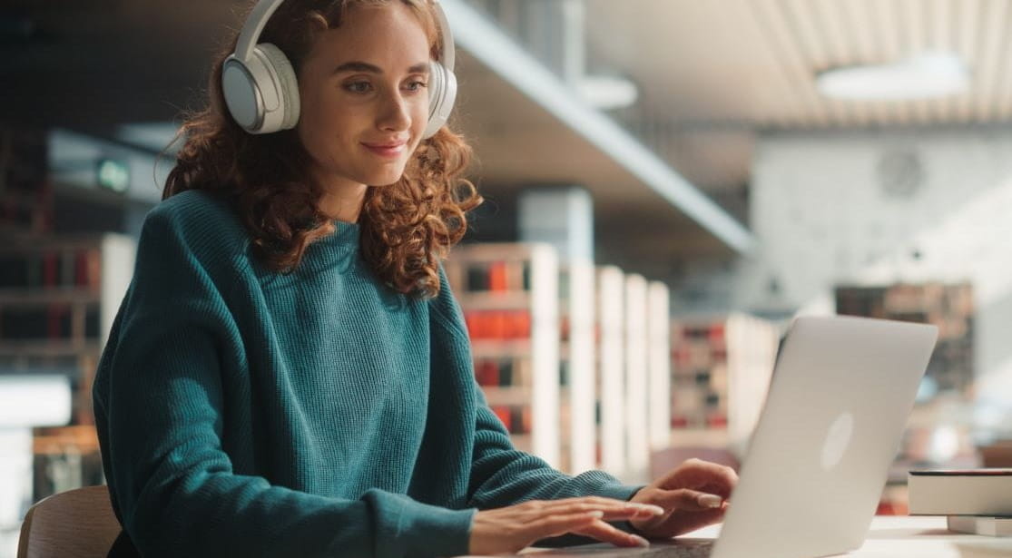 Woman on laptop wearing headphones